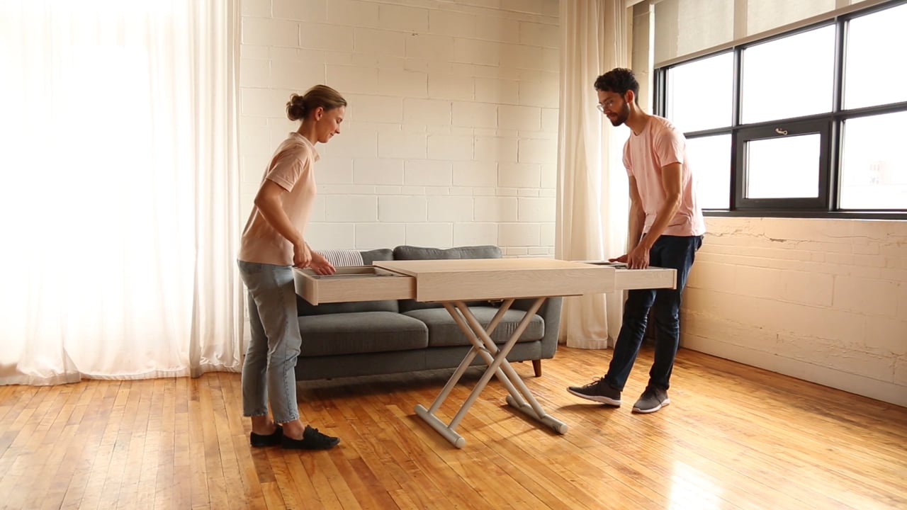 Man and woman extending a transforming table with built-in extensions